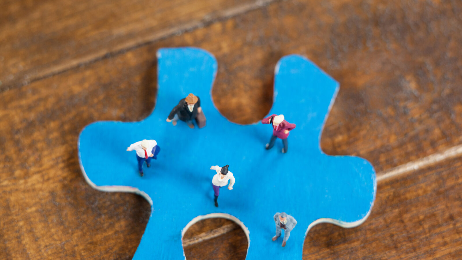 Miniature people on a jigsaw puzzle